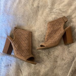 Chic booties with block heel, lazer cut panels, and elastic strap.